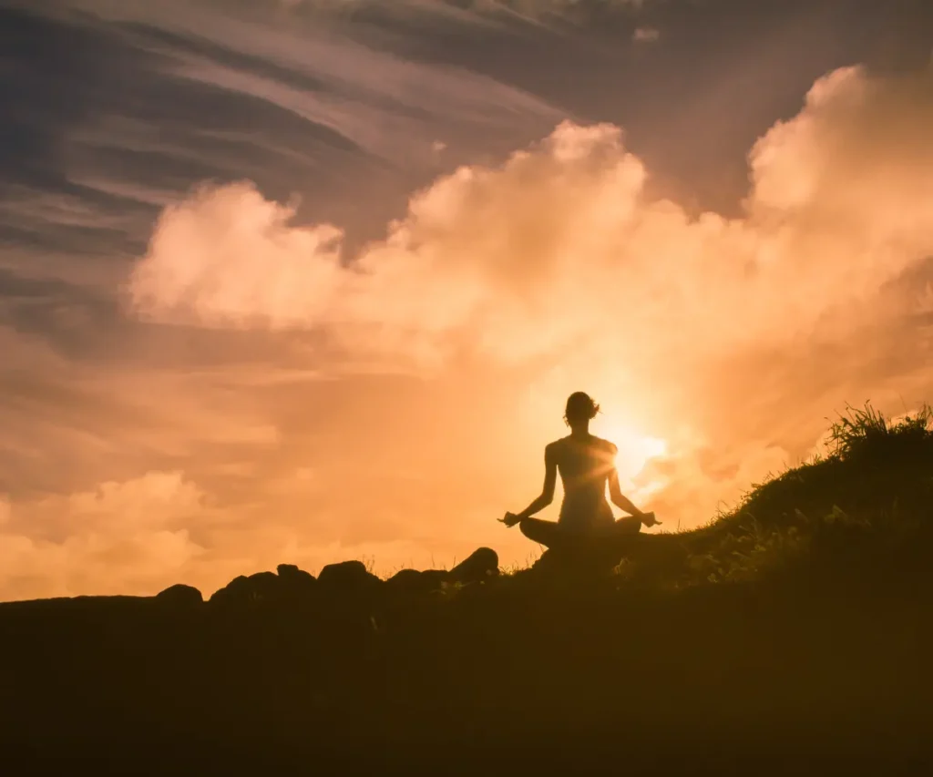 woman sitting on a clif doing meditation
