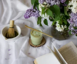 table with a vase of lilac and a notebook