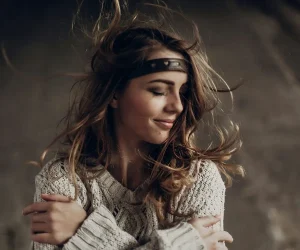 woman with leather headband and white sweater