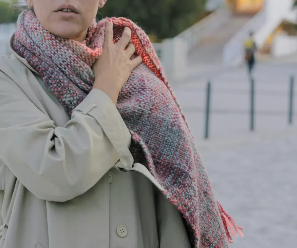 woman in a beige coat with a pink scarf